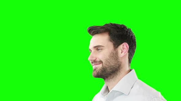 Smiling man standing against green screen