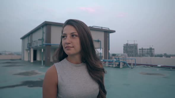 Pretty Woman with Loose Hair Walks Along Roof Slow Motion