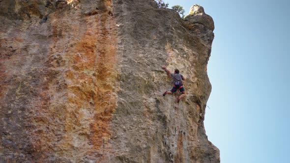 Strong and Skillful Man Climber Climbs on Vertical Limewall Crag By Challenging Route Makes Several