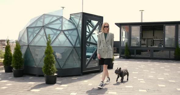 Fashionable Blonde Woman with Her Bulldog Puppy