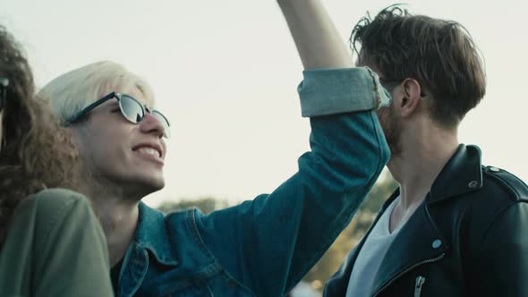 Young caucasian friends dancing on music festival with hands up and having fun. Shot with RED helium