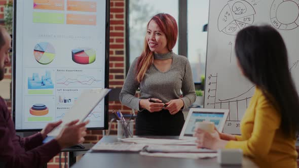 Asian Woman Doing Financial Presentation in Boardroom