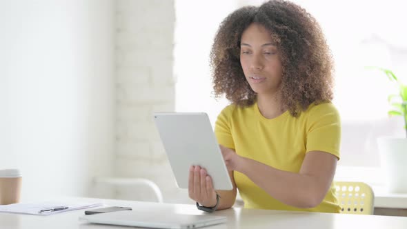 African Woman using Tablet while Sitting in Office