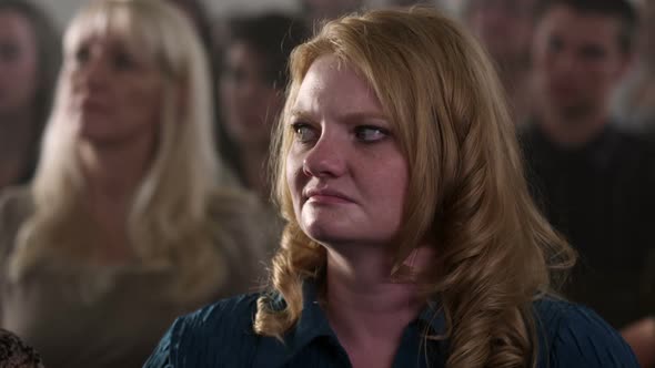 Woman in church looking around seeming upset.