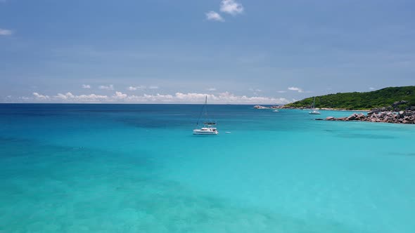 Aerial View Footage of Luxury Catamaran Yachts Moored in Transparent Turquoise Blue Lagoon Near