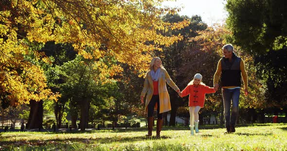 mother dad and daughter walking hand in hand outdoors