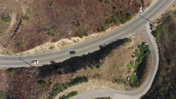 Overhead Aerial New Sport Cars Driving Zigzag By Empty Mountain Highway Road