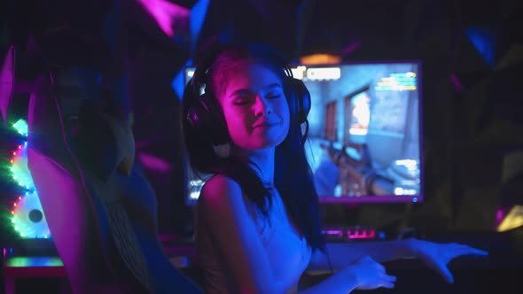 Young Woman Playing an Online Game in Gaming Club - Takes Off Her Headphones and Turns To the Camera