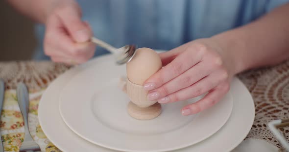 Woman Peeling Egg on Plate