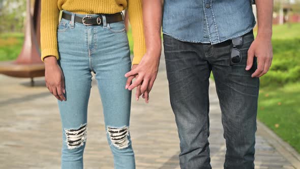 The man gently takes the young woman by the hand.