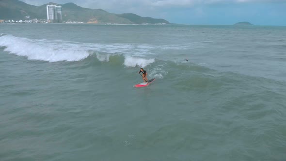 Aerial View From Above Athletic Young Women and Men Surf, Ride Big Waves with Bright Daylight