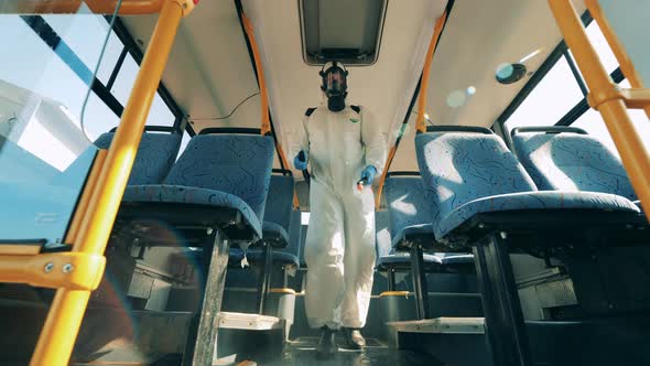 Coronavirus Prevention, Epidemic Concept. Disinfection Expert Is Walking Along the Bus and