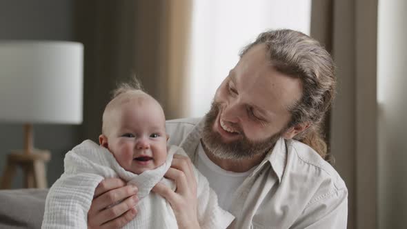 Loving Adult Bearded Father Holding Baby Newborn Caring Dad Playing with Little Daughter Son Child