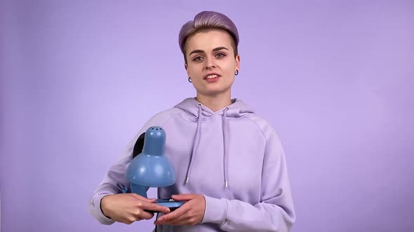 Female Zoomer Holding Old Fashioned Blue Desk Lamp Turning on Light