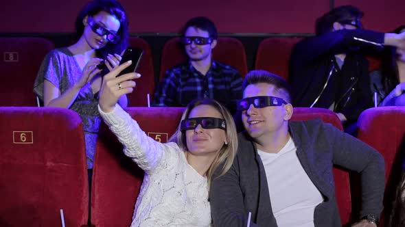 Happy Couple Taking a Selfie While Watching a Movie Together at the Cinema.