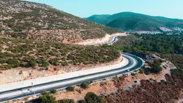 Aerial view of the mountain high-speed highway. Cars are driving along a mountain road.