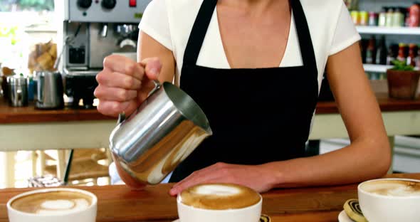 Portrait of waitress making cup of coffee at counter