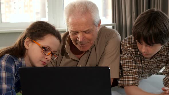 Little Girl Help Her Grandpa To Type on Laptop