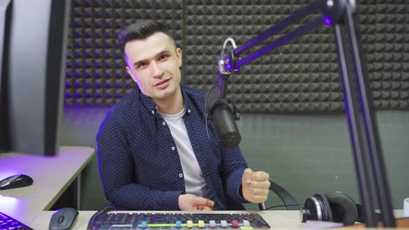 a Male Radio Host Conducts a Live Broadcast in a Professional Radio Studio