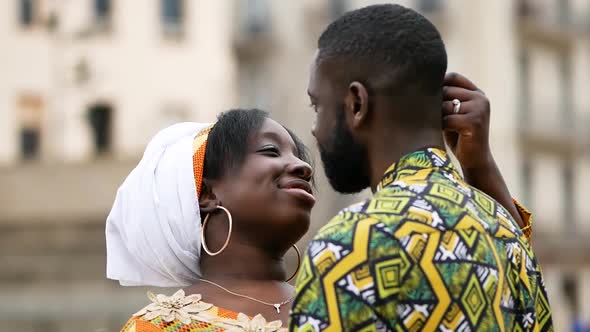 Happy ethnic couple embracing on city street