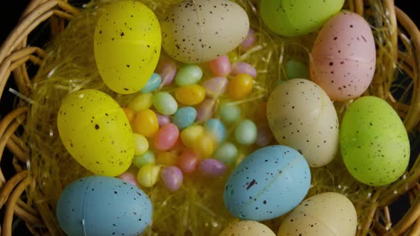 Rotating shot of Easter decorations and candy in colorful Easter grass