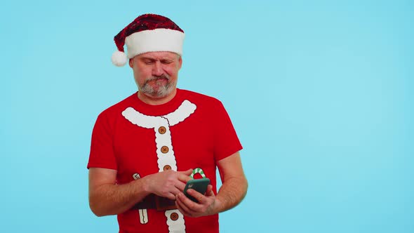Man in Christmas Tshirt Hat Using Mobile Phone Typing New Post on Web Shopping Online Browsing