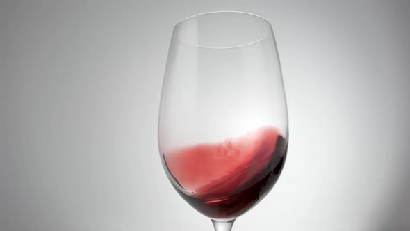 Slow Motion Shot of Red Wine Being Swirled Around Glass