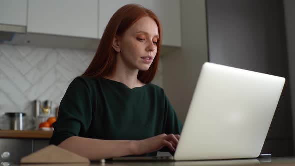 Medium Shot of Attractive Tired Redhead Young Woman Having Head Pain Working Typing on Laptop