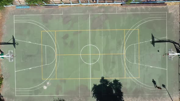 A Man Throws the Ball Into a Basketball Ring and Hits - Top View