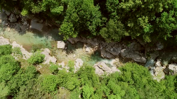 Aerial view of a person going across the Soca River on a zip line in Slovenia.