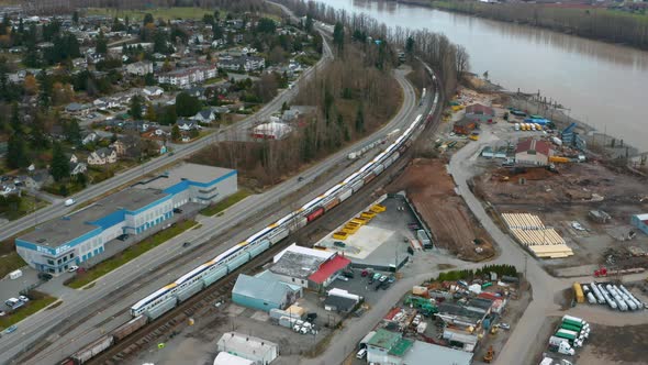 Aerial over Mission, BC, as a train travels along the shore of the Fraser River.