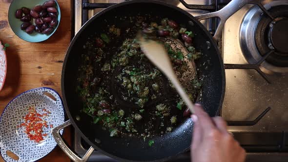 Overhead timelapse of Italian food being cooked by a chef in frying pan