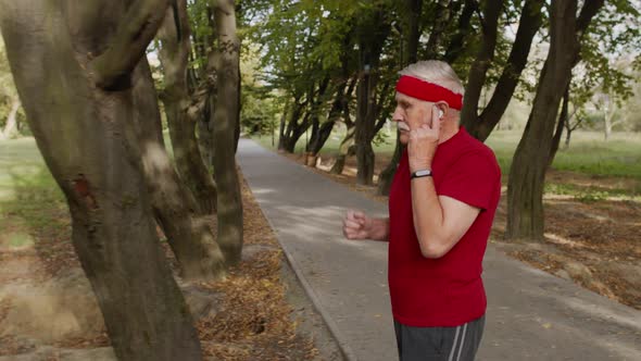 Side View of Elderly Sport Runner Man Training. Workout Cardio Outside in City Park at Morning