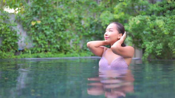 Young asian woman enjoy around outdoor swimming pool for leisure