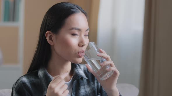 Asian Race Woman Take Drug Remedy Drinking Glass of Still Water Indoors at Home