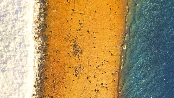 Snow, sand and water. Crystal blue water floating over golden sand while bright white snow reflects