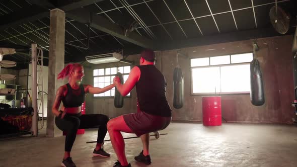 Sporty woman exercising building muscles with personal trainer at the gym