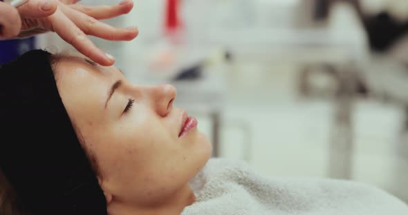 A Woman Enjoys a Facial Massage