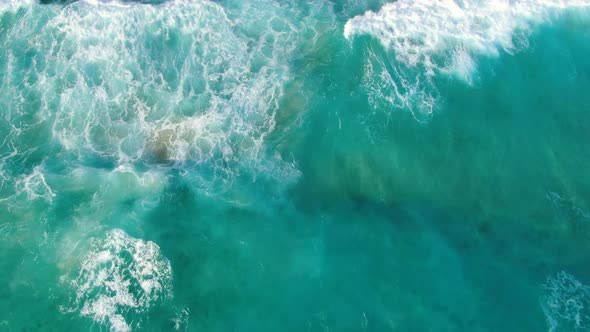 Waves crashing on a hawaiian beach with a lifeguard tower