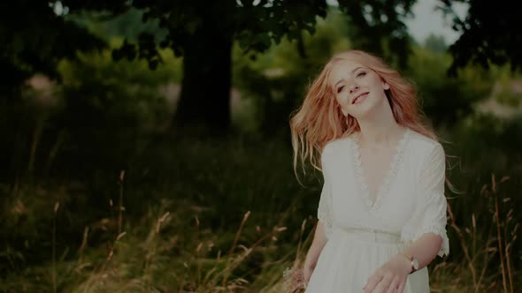 Carefree Boho Woman Walking and Smiling on a Meadow in Summer