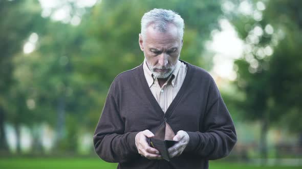 Sad Pensioner Holding Empty Wallet, Retirement Poverty, Financial Crisis, Credit