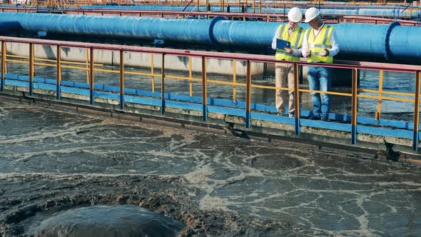 Male Workers Are Inspecting Samples of the Wastewaters. Wastewater Treatment Concept.