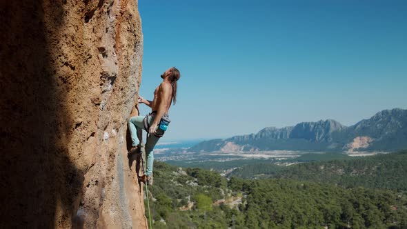 Slow Motion of Athletic Man Climbs an Vertical Rock with Rope Lead Climbing