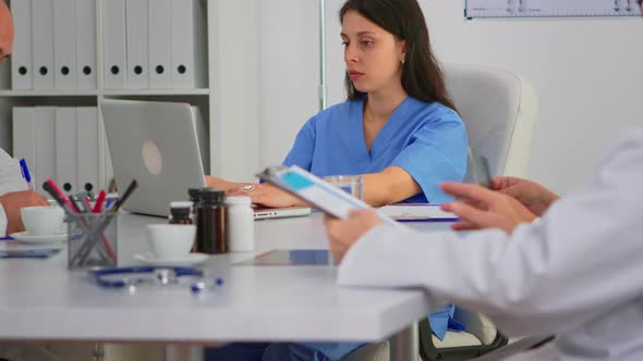 Portrait of Nurse Typing on Laptop Looking at Camera