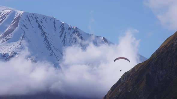 Sky-diver flying between mountains