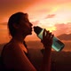 Young Mixed Race Tourist Girl Drinking Water From Plastic Bottle with Amazing Sunrise View - VideoHive Item for Sale