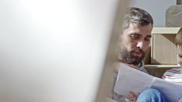 Little Boy and Father Reading Manual