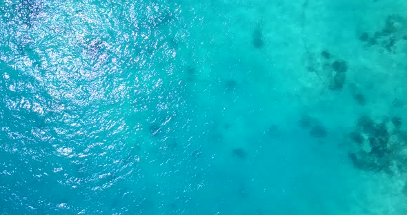 Natural fly over clean view of a white paradise beach and aqua blue ocean background in high resolut