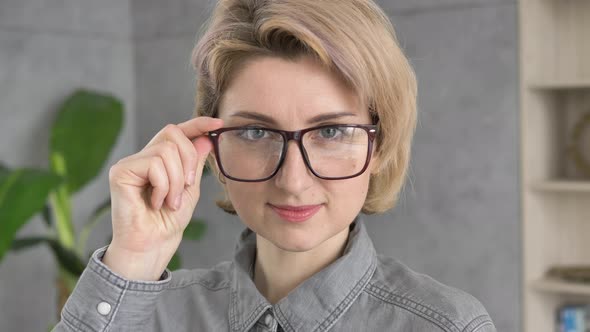 Smiling Lady with Short Fair Hair Fixes Large Glasses