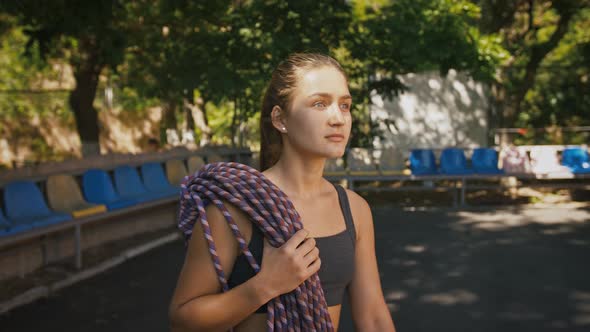 Young Sporty Woman Walking with Climbing Rope in Park Outdoor Shot